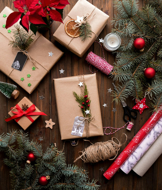 Paquets cadeaux en kraft, branches de sapin et boules rouges