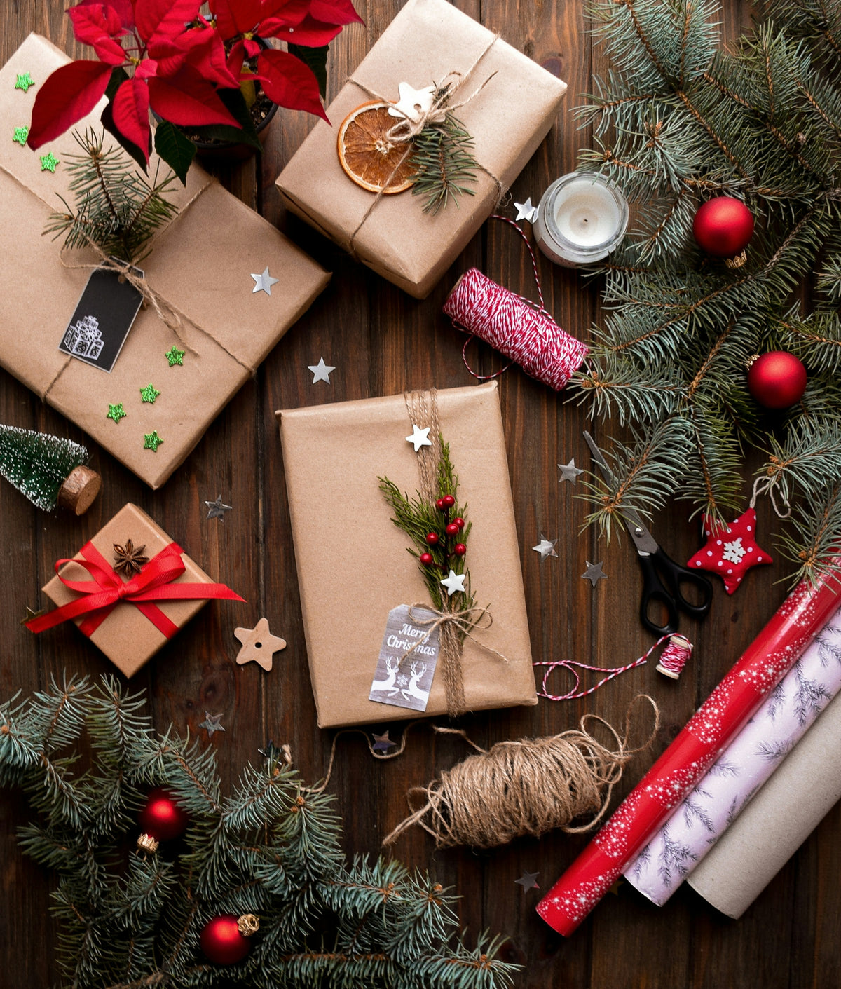 Paquets cadeaux en kraft, branches de sapin et boules rouges